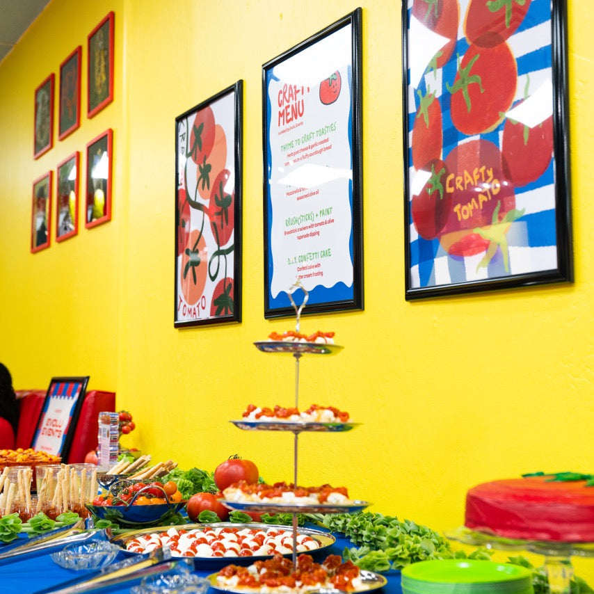 Colorful food display with framed pictures on a yellow wall